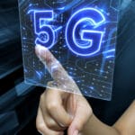 Female's hand touching a digital 3D render screen with 5G sign