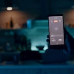 Person holding mobile with high tech application turning on lights